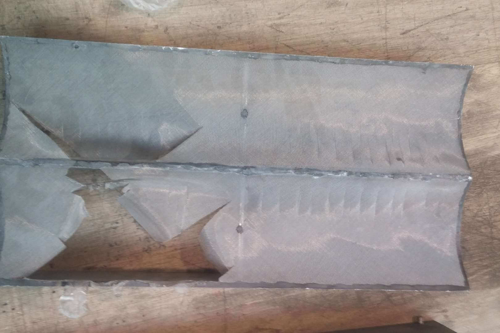 Gescheurd metalen filterelement vóór herstelling door Omnimesh