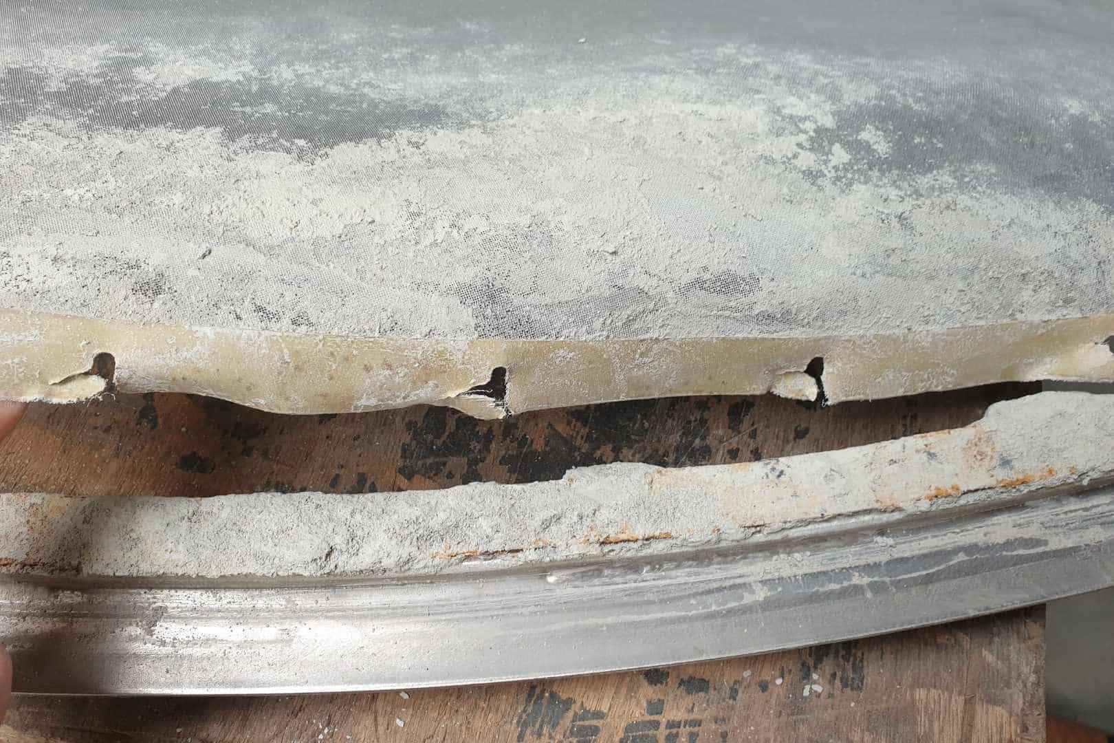 Gescheurd zeefgaas, klaar voor herstel en vervanging met een nieuw filtergaas door Omnimesh