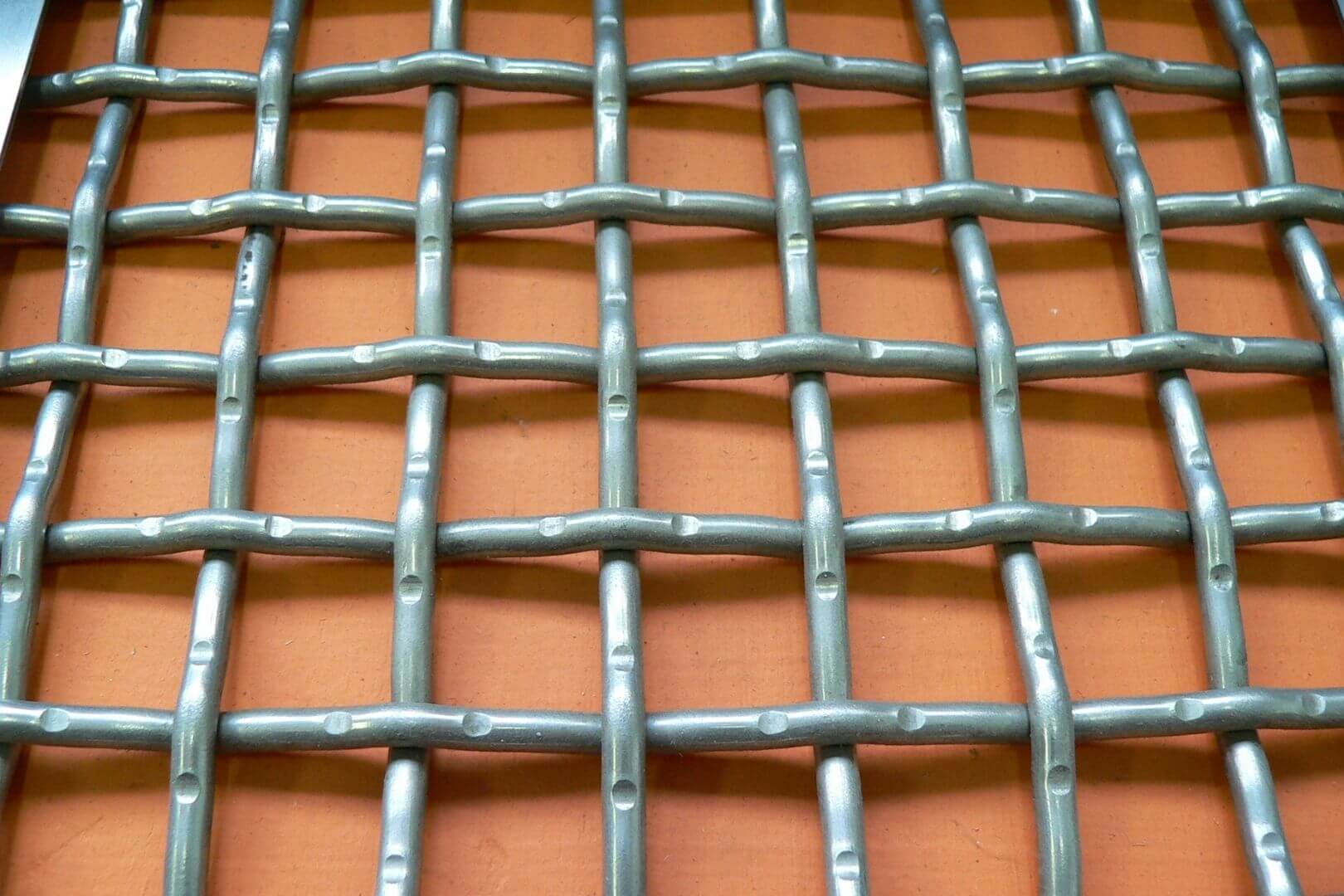 Detailfoto van dubbel voorgolfde gevlochten roosters met ronde metalen draden voor industriële roosters, zeefgaas en maatwerktoepassingen.