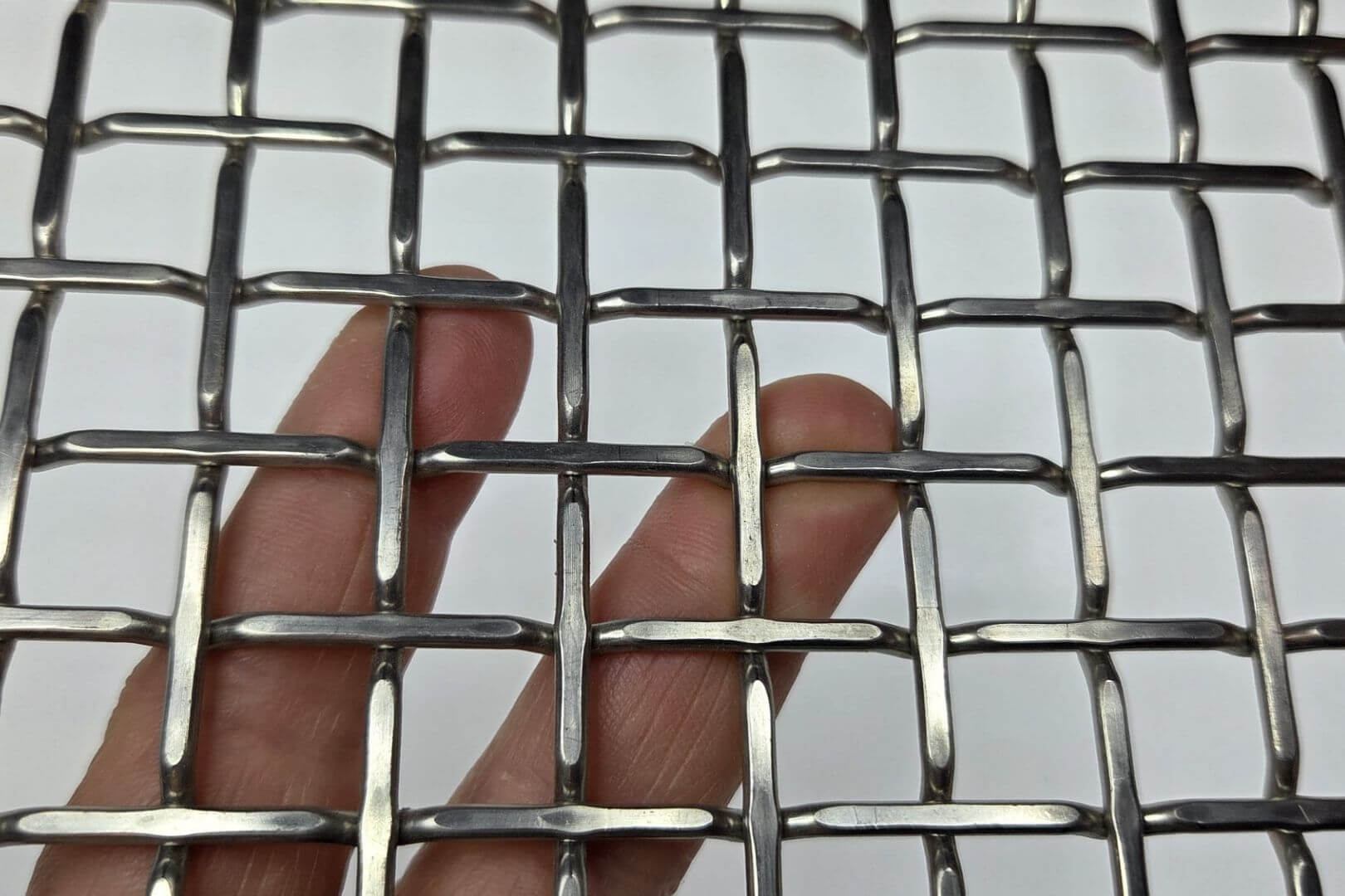 Detailfoto van flat top voorgolfd vlechtwerk met vierkante mazen en vlakke bovenzijde voor industriële roosters en maatwerktoepassingen.