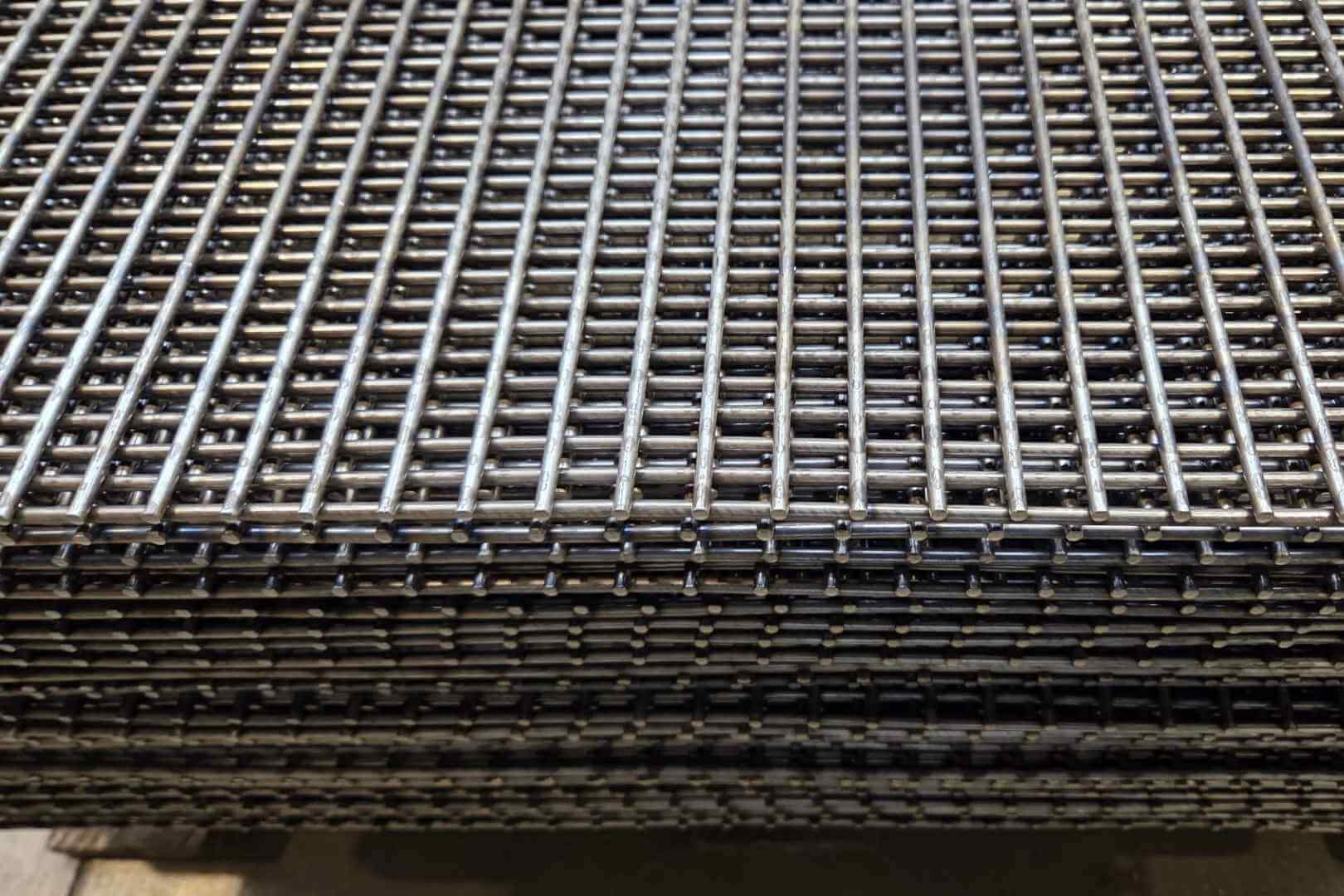 Detailfoto van gepuntlaste metalen roosters en gelast gaas voor industriële toepassingen, afscherming en maatwerkconstructies.