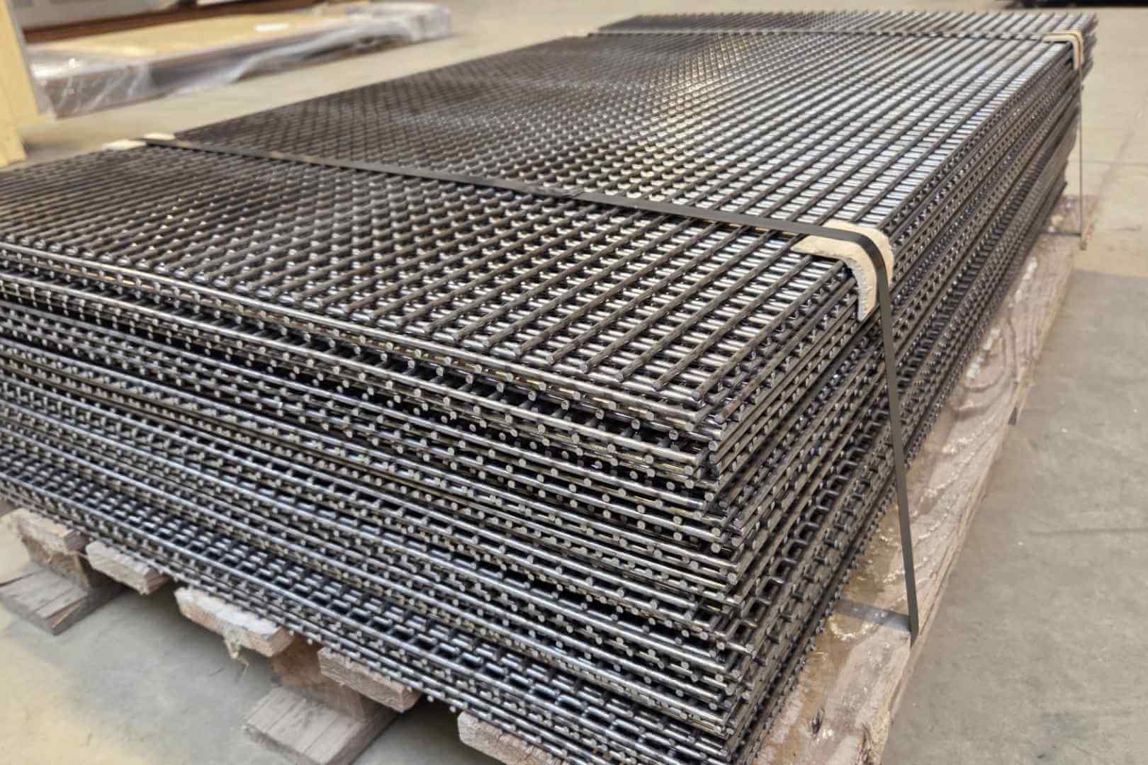 Stapel gepuntlaste metalen roosters en gelast gaas voor industriële toepassingen, afscherming en maatwerkconstructies.