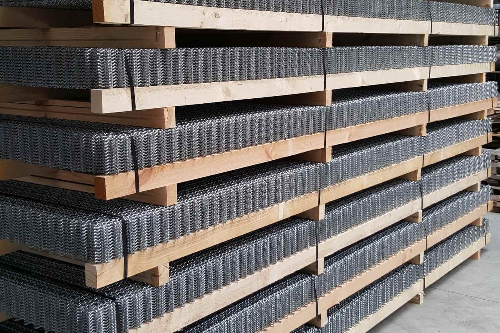 Gestapelde zeefdekken in geweven metaalgaas op houten pallets voor industriële zeving en materiaalafscheiding