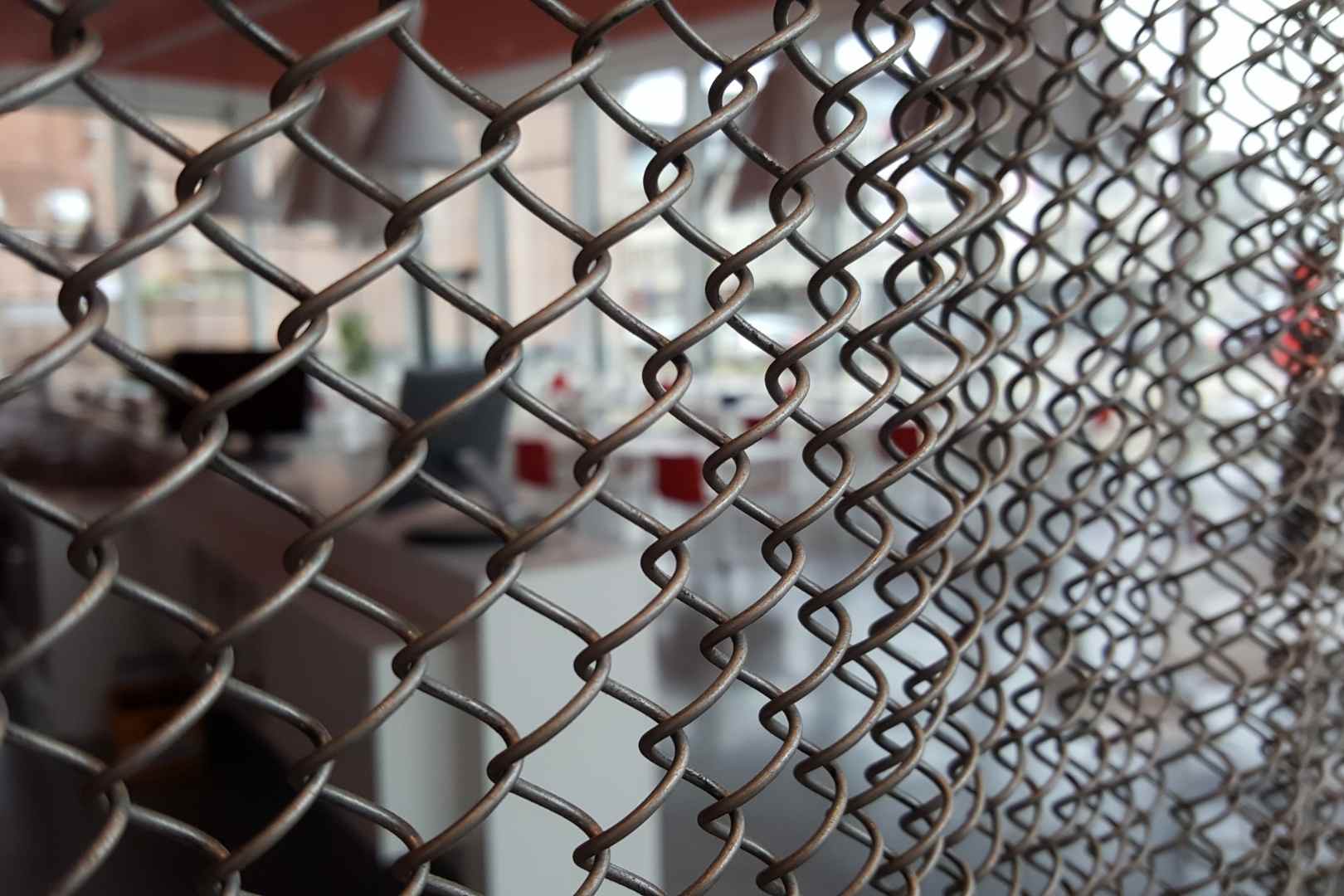 Close-up van een metalen spiraalgordijn als decoratieve en transparante afscheiding in een architecturaal interieur